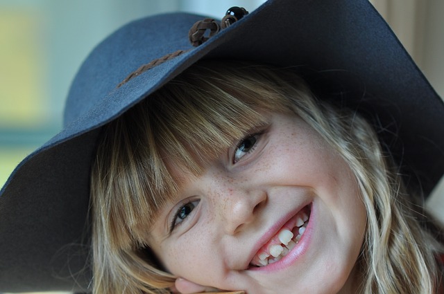 Girl in a hat, smiling towards the camera