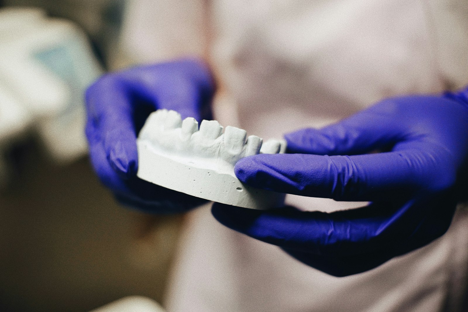 freestocks-Qx5QNarbrUM-unsplash A close up of a person wearing blue gloves holding a toothbrush